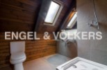 Charming attic bathroom with wooden walls, skylights, and modern fixtures.