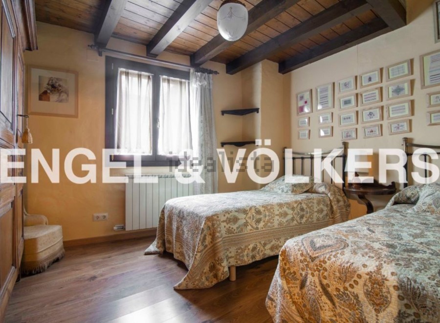 Charming rustic bedroom with twin beds, wooden beamed ceiling, and antique wardrobe.