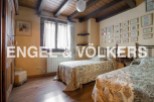 Charming rustic bedroom with twin beds, wooden beamed ceiling, and antique wardrobe.