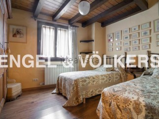 Charming rustic bedroom with twin beds, wooden beamed ceiling, and antique wardrobe.