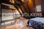 Charming attic bedroom with wooden beams, skylights, and a cozy atmosphere.