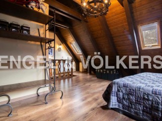 Charming attic bedroom with wooden beams, skylights, and a cozy atmosphere.