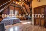 Rustic attic bedroom with wooden beams, twin beds, and ample storage.