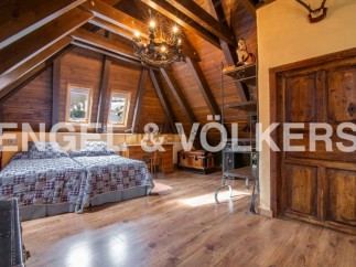 Rustic attic bedroom with wooden beams, twin beds, and ample storage.