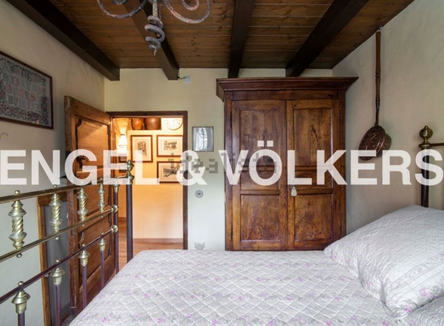 Charming bedroom with antique wooden wardrobe and brass bed frame.