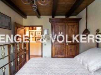 Charming bedroom with antique wooden wardrobe and brass bed frame.