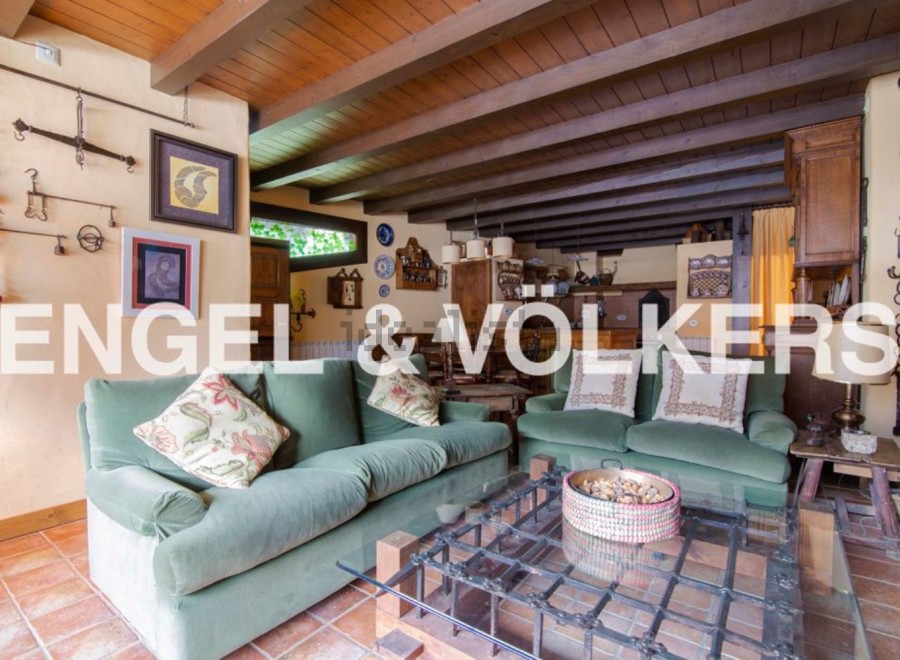 Rustic living room with exposed wooden beams and a charming fireplace.