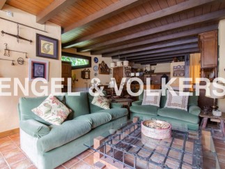 Rustic living room with exposed wooden beams and a charming fireplace.