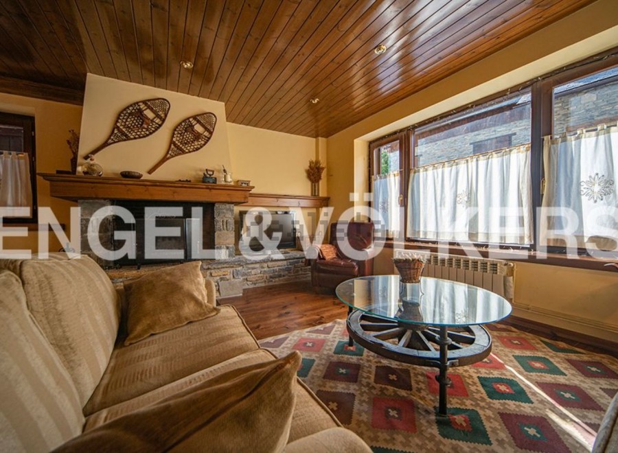 Rustic living room with a cozy fireplace and large windows offering ample natural light.