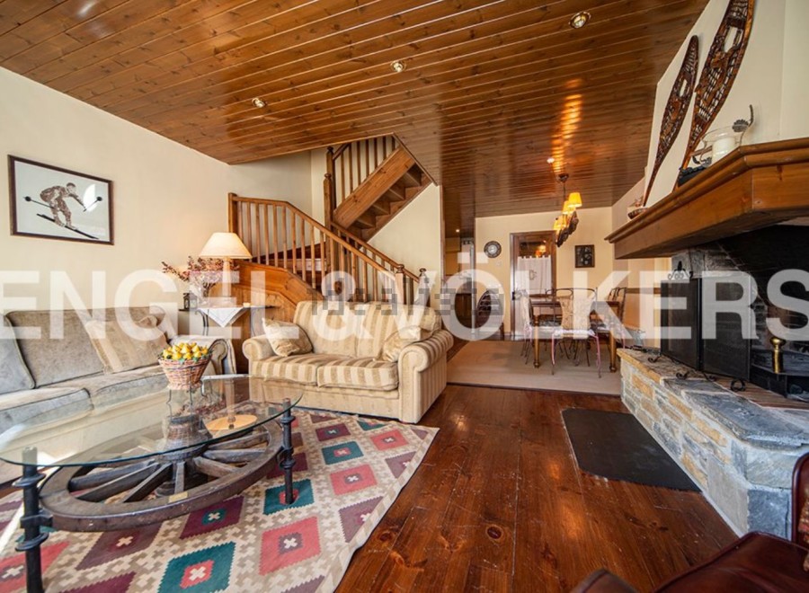 This stunning chalet boasts a spacious living area with hardwood floors, a cozy fireplace, and ample natural light.