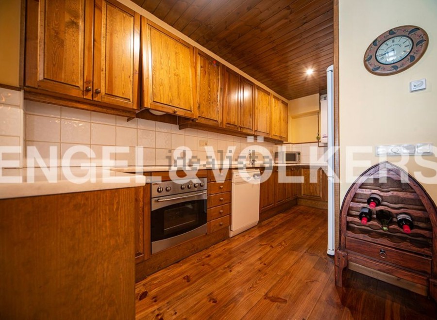 Rustic kitchen with wooden cabinets and flooring.