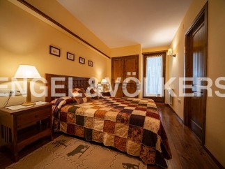 Cozy bedroom with a patchwork quilt and wooden furniture.