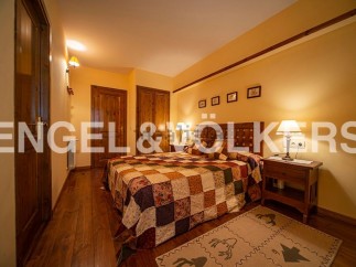 Cozy mountain chalet bedroom with wooden floors and patchwork quilt.
