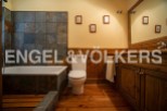 This charming bathroom boasts a rustic-chic design with slate tile, wooden cabinetry, and hardwood floors.