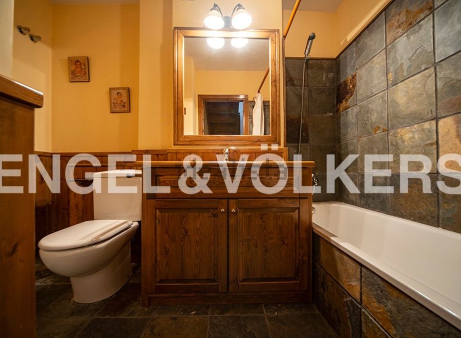 Charming bathroom with wooden vanity and slate tile.