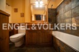 Charming bathroom with wooden vanity and slate tile.