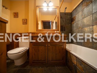 Charming bathroom with wooden vanity and slate tile.