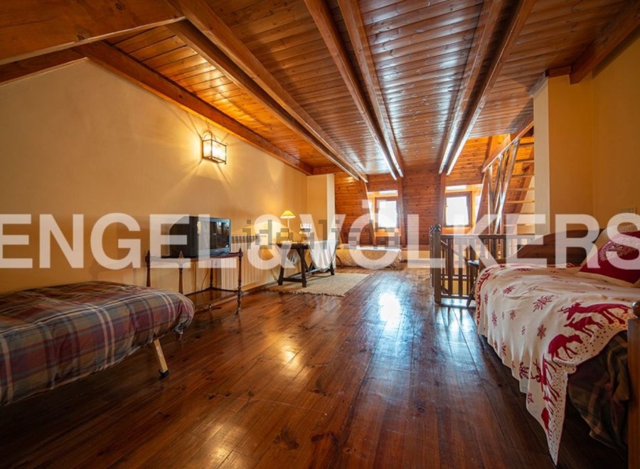 This charming attic room boasts a rustic wooden interior with exposed beams and hardwood floors.