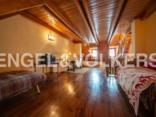This charming attic room boasts a rustic wooden interior with exposed beams and hardwood floors.
