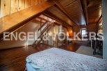Discover this charming attic bedroom with wooden beams and flooring, offering a cozy and rustic atmosphere.