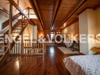 This stunning property boasts a spacious loft with exposed wooden beams and hardwood floors, creating a warm and inviting atmosphere.