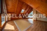 This attic room boasts a stunning wooden ceiling and large windows offering breathtaking mountain views.