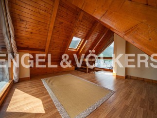 This attic room boasts a stunning wooden ceiling and large windows offering breathtaking mountain views.