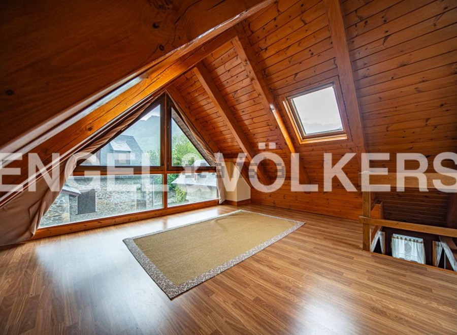 Discover this charming attic room boasting a stunning view and natural wood finishes.