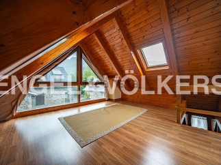 Discover this charming attic room boasting a stunning view and natural wood finishes.