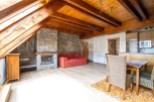 This stunning attic apartment boasts a spacious open-plan living area with exposed wooden beams and a cozy fireplace.