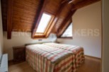 Cosy attic bedroom with wooden beams and skylights.