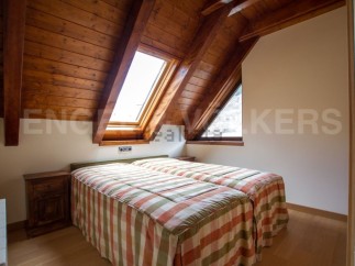 Cosy attic bedroom with wooden beams and skylights.