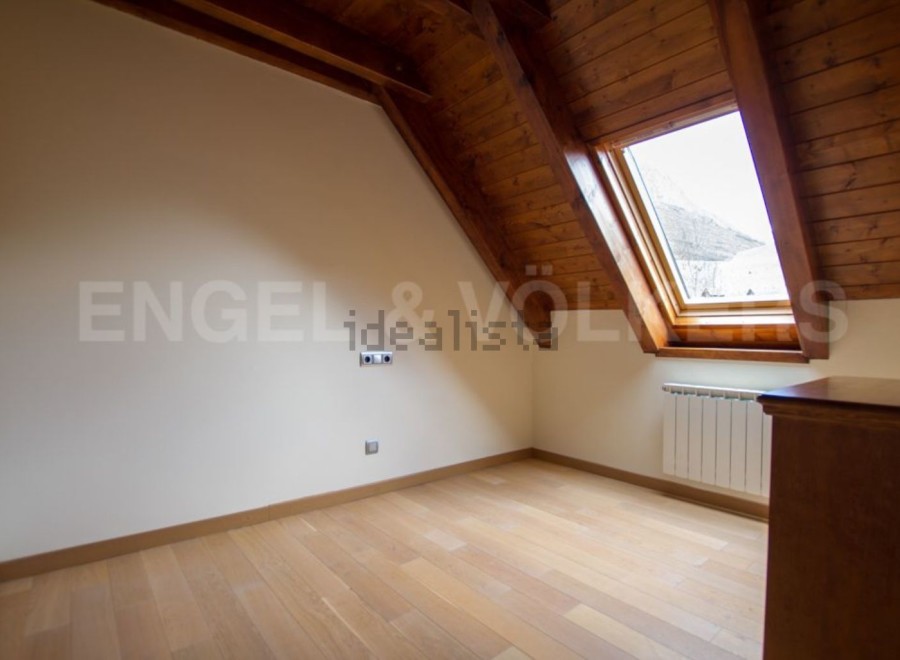 Charming attic room with wooden beams and skylight.