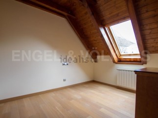 Charming attic room with wooden beams and skylight.