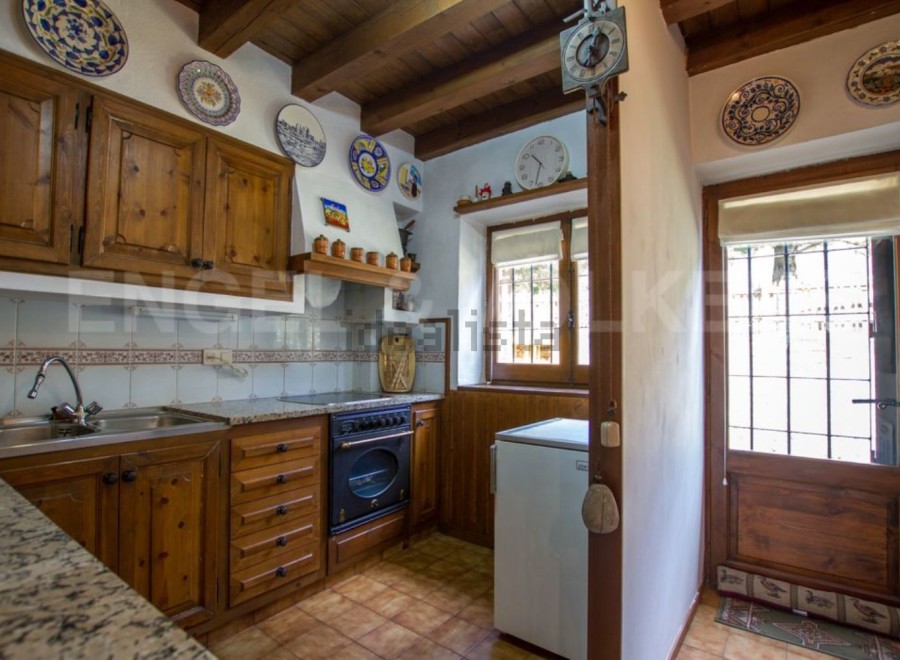 Rustic kitchen with wooden cabinets and granite countertops.