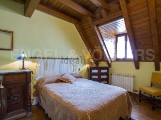 Charming attic bedroom with wooden beams, offering a cozy and rustic atmosphere.