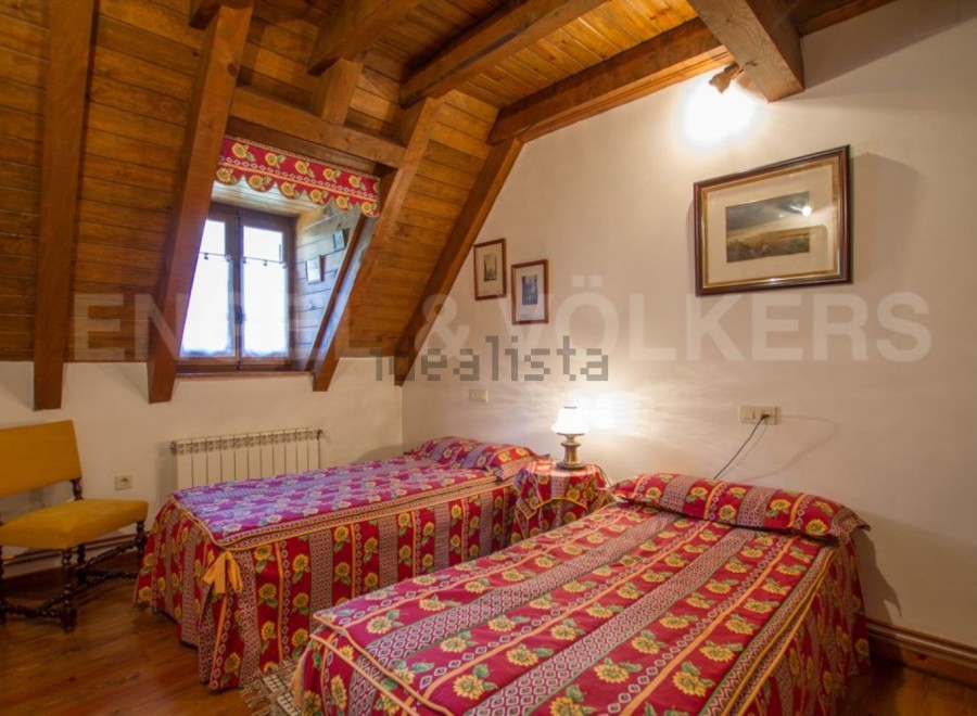 Charming attic bedroom with twin beds, exposed wooden beams, and a rustic feel.