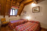 Charming attic bedroom with twin beds, exposed wooden beams, and a rustic feel.