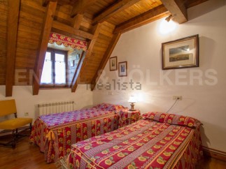 Charming attic bedroom with twin beds, exposed wooden beams, and a rustic feel.