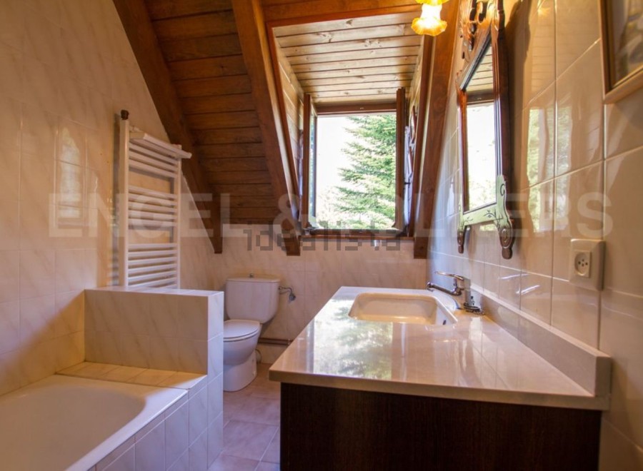 Charming bathroom with wooden beams and a view.