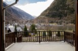 Mountain views from a balcony with wooden railings.