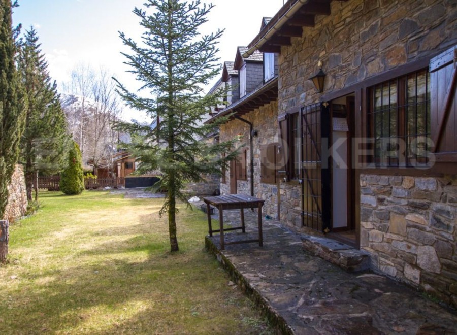 Charming stone house nestled in a serene mountain setting.