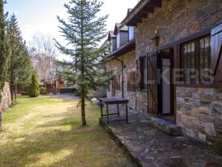 Charming stone house nestled in a serene mountain setting.