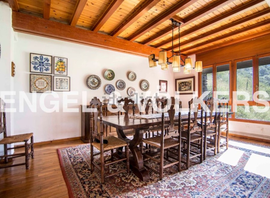 This stunning dining room boasts a beautiful wooden ceiling and large windows offering breathtaking views.