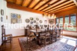 This stunning dining room boasts a beautiful wooden ceiling and large windows offering breathtaking views.