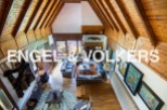 This stunning property boasts a spacious open-plan living area with high, wood-beamed ceilings, creating a warm and inviting atmosphere.