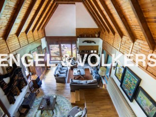 This stunning property boasts a spacious open-plan living area with high, wood-beamed ceilings, creating a warm and inviting atmosphere.