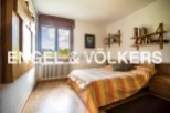 This charming bedroom boasts a tranquil view and features hardwood floors, built-in shelving, and ample natural light.