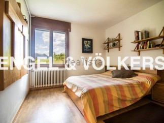 This charming bedroom boasts a tranquil view and features hardwood floors, built-in shelving, and ample natural light.
