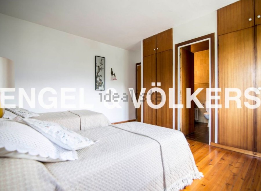 Charming bedroom with twin beds and built-in wooden wardrobes.